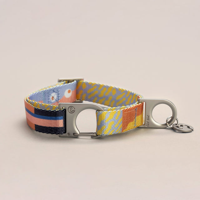 Fur Sie Una collar featuring playful pastel pattern with a silver wire-gate lock and logo charm on a light gray background