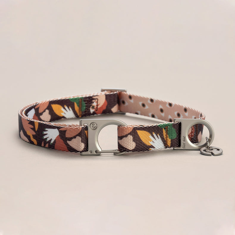 Fur Sie Clemens collar featuring an abstract earthy-toned pattern with a silver wire-gate lock and logo charm on a light gray background