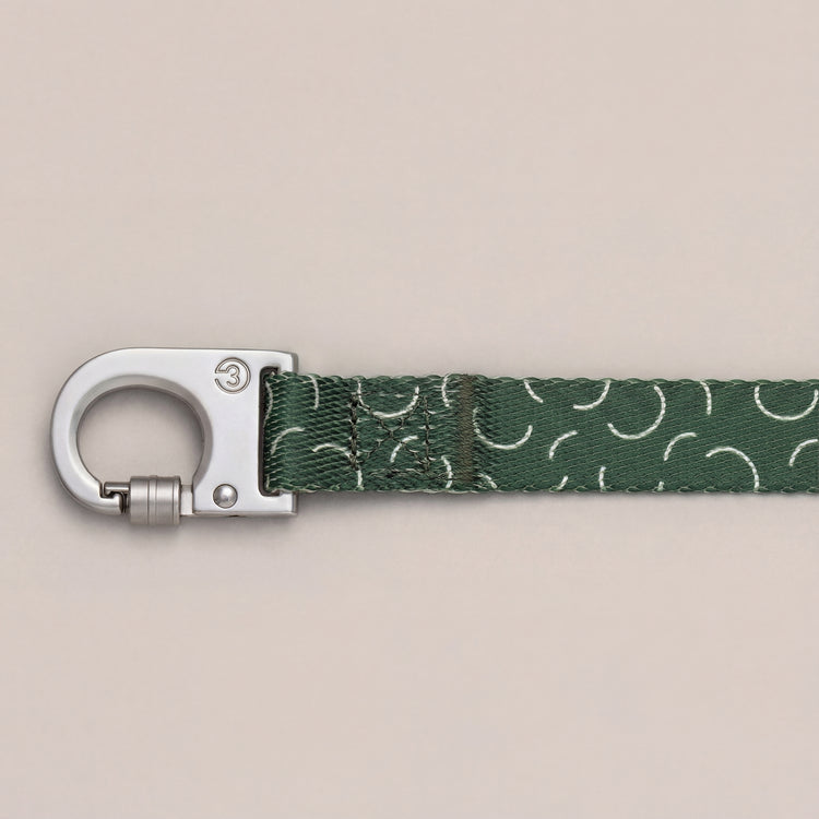 Sabine dog leash with push-lock metal hook and green pattern on a neutral background