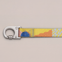 Close-up of the Una leash push-lock hook and colorful pattern on a gray background