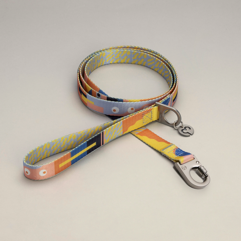 Fur Sie Una dog leash with soft yellows, pale blues, and gentle peach tones on a light gray background