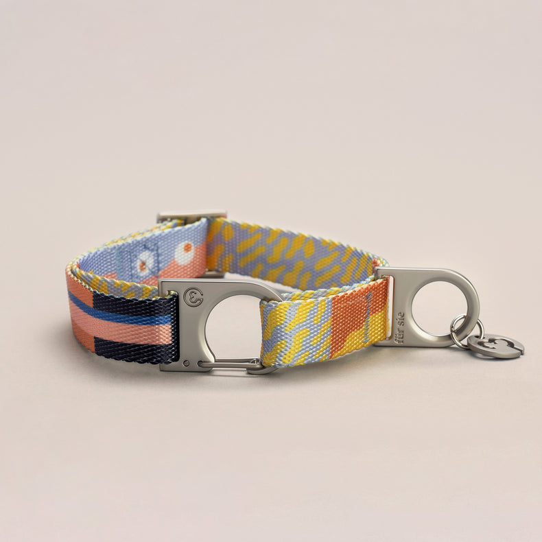 Fur Sie Una collar featuring playful pastel pattern with a silver wire-gate lock and logo charm on a light gray background